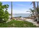 Scenic waterfront view with rocks, palm trees, sandy beach and blue water under a partly cloudy sky at 403 29Th Nw St, Bradenton, FL 34205