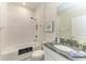 Bathroom with white tiled shower, granite vanity, and floral decoration at 4324 Dairy Ct, Lakewood Ranch, FL 34211