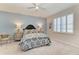 Comfortable bedroom with a large window, stylish bed, neutral carpet, and soft blue accent wall at 4324 Dairy Ct, Lakewood Ranch, FL 34211