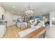 Bright dining area featuring a farmhouse-style table, chandelier, and view into kitchen and living room at 4324 Dairy Ct, Lakewood Ranch, FL 34211