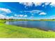 Picturesque lake view from the property with a grassy shoreline and clear blue water at 4324 Dairy Ct, Lakewood Ranch, FL 34211