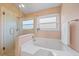 Bathroom features a large bathtub, glass enclosed shower, and natural light at 4330 Beekman Pl # 103, Sarasota, FL 34235