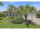 A well-maintained front yard features lush landscaping and palm trees enhancing curb appeal of home at 4330 Beekman Pl # 103, Sarasota, FL 34235