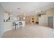 Spacious living area showcasing tile flooring, breakfast bar seating, and an open layout with natural light at 4330 Beekman Pl # 103, Sarasota, FL 34235