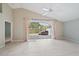 An empty living room boasts ceramic tile flooring and sliding glass doors to the screened lanai at 4330 Beekman Pl # 103, Sarasota, FL 34235