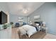 Comfortable bedroom with blue walls, a ceiling fan, and light wood floors at 4330 Beekman Pl # 103, Sarasota, FL 34235