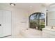 Soaking tub under an arched window in a stylish bathroom at 4330 Presidential Avenue E Cir, Bradenton, FL 34203