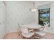 Bright breakfast nook features a charming chandelier, floral wallpaper, and a view of the pool at 4330 Presidential Avenue E Cir, Bradenton, FL 34203