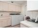 Functional laundry room with washer, dryer, sink, and ample storage space at 4330 Presidential Avenue E Cir, Bradenton, FL 34203