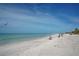 Serene beach view with white sands, clear water, and people relaxing under umbrellas, creating a tranquil atmosphere at 444 S Polk Dr, Sarasota, FL 34236