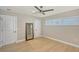 Bedroom with light wood floors, neutral walls, shuttered windows, and three doors at 444 S Polk Dr, Sarasota, FL 34236