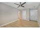Neutral toned bedroom with light wood floors, a ceiling fan, built in storage and an adjacent bathroom entrance at 444 S Polk Dr, Sarasota, FL 34236