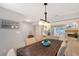 Inviting dining area with a wooden table, seating for six, and open view of the pool and living room at 444 S Polk Dr, Sarasota, FL 34236