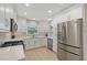 Bright, all-white kitchen featuring stainless steel appliances, quartz countertops, and ample cabinet space at 444 S Polk Dr, Sarasota, FL 34236