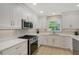 Modern kitchen featuring white cabinets, stainless steel appliances, and quartz countertops at 444 S Polk Dr, Sarasota, FL 34236