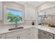 Spacious white kitchen with stainless steel appliances, modern countertops, and an open view to the dining area at 444 S Polk Dr, Sarasota, FL 34236