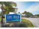 Lido Beach Pool & Pavilion entrance sign with palm trees and lush landscaping, inviting visitors to the scenic location at 444 S Polk Dr, Sarasota, FL 34236