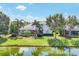 Backyard view featuring a screened pool area, lush landscaping, and picturesque water view at 4714 Seneca Park Trl, Bradenton, FL 34211