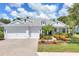 Charming single-story home with a well-manicured lawn, colorful flower beds, and a three-car garage at 4714 Seneca Park Trl, Bradenton, FL 34211