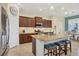 Modern kitchen featuring an island with seating, granite countertops, and stainless steel appliances at 4714 Seneca Park Trl, Bradenton, FL 34211