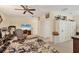 Spacious living room with a television, ceiling fan, treadmill, and adjacent storage cabinets at 4714 Seneca Park Trl, Bradenton, FL 34211