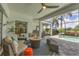 Inviting covered outdoor patio with comfortable seating, fire pit, and a view of the pool and lush landscaping at 4714 Seneca Park Trl, Bradenton, FL 34211