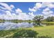 Scenic view of a tranquil pond reflecting the blue sky and fluffy white clouds on a sunny day at 4714 Seneca Park Trl, Bradenton, FL 34211
