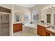 Bright bathroom features a soaking tub, dual vanities, neutral tile, and a separate shower providing a luxurious feel at 5179 Cantabria Crst, Sarasota, FL 34238