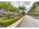 Welcoming entrance to a gated community with manicured landscaping, water features, and a secure entry system at 5179 Cantabria Crst, Sarasota, FL 34238