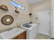 Functional laundry room featuring modern washer, dryer, storage and a utility sink for added convenience at 5179 Cantabria Crst, Sarasota, FL 34238