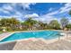 Sparkling community pool surrounded by lush tropical landscaping and comfortable lounge chairs at 5179 Cantabria Crst, Sarasota, FL 34238