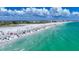 Stunning aerial shot of Siesta Key beach with crystal-clear water, white sand, and tourists enjoying the coastal scenery at 5572 Shadow Lawn Dr, Sarasota, FL 34242