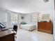 Simple bedroom with two windows, wooden furniture, and an overhead light at 5572 Shadow Lawn Dr, Sarasota, FL 34242