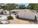 Charming single-story home with a white exterior, pink shutters, manicured landscaping, and spacious driveway at 5572 Shadow Lawn Dr, Sarasota, FL 34242