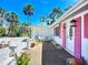 Charming home exterior with pink shutters and a welcoming front patio and lush tropical foliage at 5572 Shadow Lawn Dr, Sarasota, FL 34242