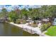 Waterfront home with a dock and lush landscaping, providing a serene and inviting outdoor space at 5572 Shadow Lawn Dr, Sarasota, FL 34242
