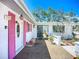 Inviting front entrance featuring an adorned front door, pink shutters, and lush landscaping enhancing curb appeal at 5572 Shadow Lawn Dr, Sarasota, FL 34242