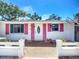 Welcoming front entrance features bright pink shutters, stylish door, and picturesque landscaping, adding charm at 5572 Shadow Lawn Dr, Sarasota, FL 34242