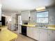 Retro kitchen featuring white cabinets, yellow countertops, and vintage appliances at 5572 Shadow Lawn Dr, Sarasota, FL 34242