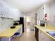 Retro kitchen featuring white cabinets, yellow countertops, and vintage appliances at 5572 Shadow Lawn Dr, Sarasota, FL 34242