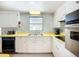 Retro kitchen featuring white cabinets, yellow countertops, and vintage appliances at 5572 Shadow Lawn Dr, Sarasota, FL 34242