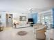 Bright living room featuring white furniture, light flooring, and large windows with blue curtains at 5572 Shadow Lawn Dr, Sarasota, FL 34242