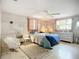 Bright main bedroom with a ceiling fan, dual windows, and a cozy sitting area at 5572 Shadow Lawn Dr, Sarasota, FL 34242