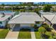 An aerial view of a home with a canal view, white tile roof and vibrant yellow shutters and door at 564 Spanish N Dr, Longboat Key, FL 34228
