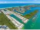 Breathtaking aerial view of waterfront homes with boat docks, leading out to the ocean, surrounded by lush greenery at 564 Spanish N Dr, Longboat Key, FL 34228
