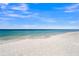 Beautiful white sand beach with clear blue water under a bright blue sky at 564 Spanish N Dr, Longboat Key, FL 34228