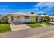 Charming single-story home featuring a white tile roof, yellow shutters, and well-maintained front lawn at 564 Spanish N Dr, Longboat Key, FL 34228