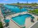 Aerial view of a community pool with lounge chairs and tables, next to a waterfront with docked boats at 564 Spanish N Dr, Longboat Key, FL 34228