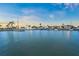 Picturesque waterfront scene with boats docked at twilight, palm trees in the distance, and a serene canal at 564 Spanish N Dr, Longboat Key, FL 34228