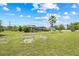 Large grassy backyard with a view of the home's pool enclosure and manicured landscaping at 6103 6Th Nw Ave, Bradenton, FL 34209